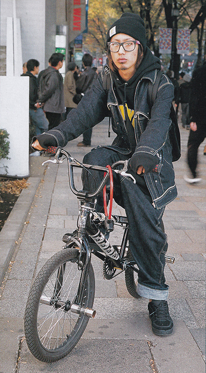 Photo of a man sitting on a BMX bike wearing denim street style fashion on
    Omotesando Street in Tokyo