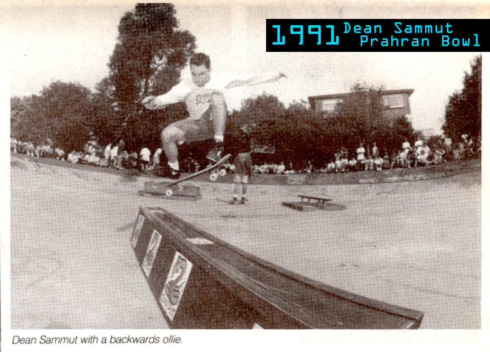 Black and white photo of Dean Sammut doing a fakie ollie over wooden and metal rail obstacle in the middle of
    Prahran Bowl. Dean is mid-air - floating above the obstacle. Spectators look on around the perimeter of the bowl.