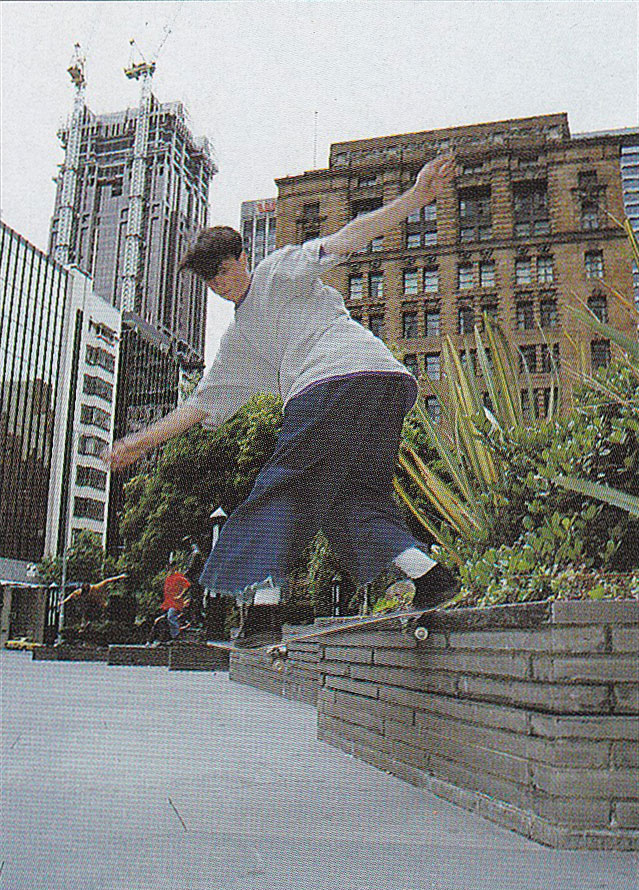 Photo from the 1990s of Ryan Denereaz wearing baggy denim jeans and loose fitting streetwear doing 
    a tailslide in the city.