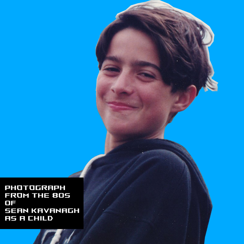 Text on the image reads 'Photograph from the 80s of Sean Kavanagh as a child'.
    Sean with a big smile and is wearing a Stussy Hooded Sweater. The background is sky blue.
