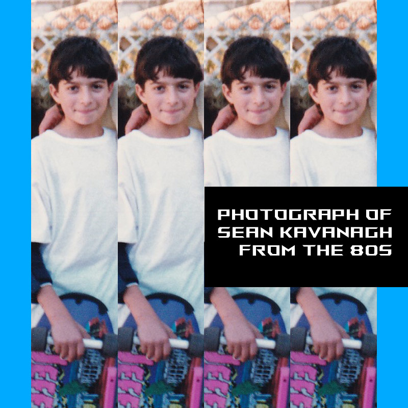 Sean at a very young age - wearing elbow pads holding a classic Jeff Kendall Skateboard with a nose guard and pink rails.