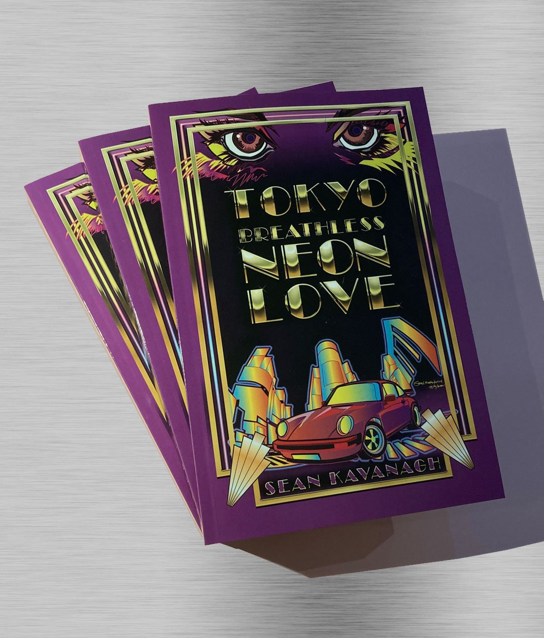 A Stack of TOKYO BREATHLESS NEON LOVE books on a smooth metal background.